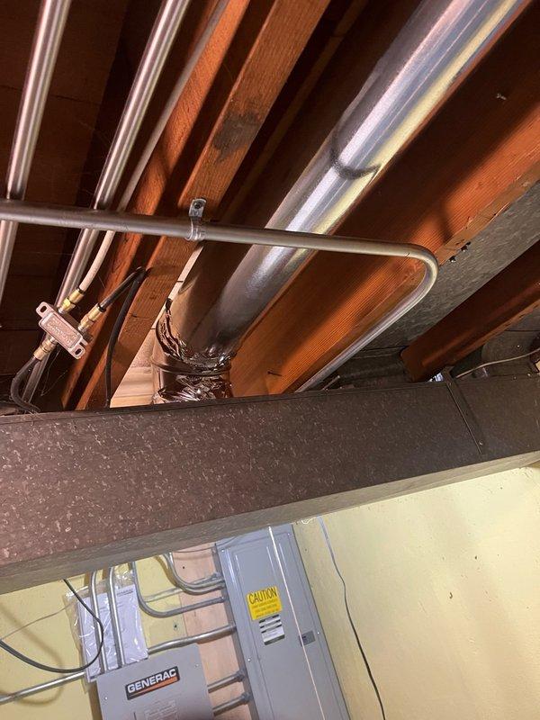 Installed four new 6-inch supply air branch runs in the basement ceiling and connected them to the existing supply trunk line. Installed two new 7-inch return air branch runs low on the basement wall and connected them to the existing return trunk line. Mounted four new supply registers and two new return grilles at designated locations. Removed abandoned 1/4-inch copper line and humidifier solenoid valve, then capped the existing piercing valve to complete the ductwork modifications.