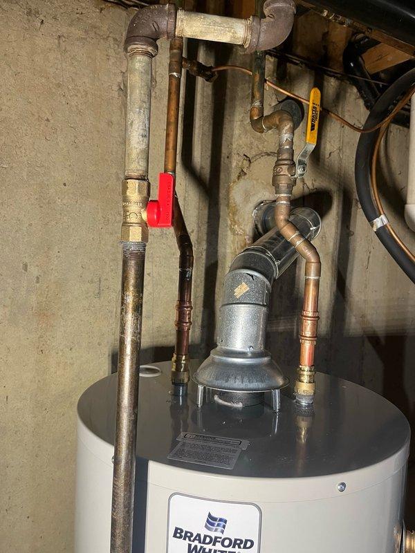 Completed replacement of 40-gallon Bradford White tanked water heater. Removed existing unit and installed new water heater with proper venting and flue assembly. Replaced 1/2" gas cock for improved safety and code compliance. Connected copper water supply lines with brass fittings and installed red-handled shut-off valve on cold water supply line. Verified all plumbing connections were secure and leak-free. Tested water temperature output at fixture, confirming proper operation at 36.8°C. All work performed to manufacturer specifications and local plumbing codes.