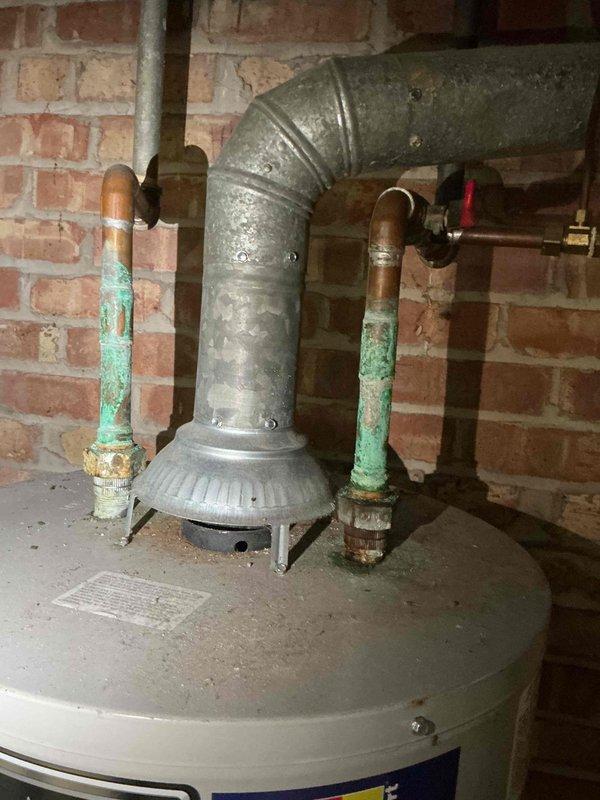 Responded to service call for water heater with extinguished pilot light resulting in no hot water. Upon arrival, inspected tanked water heater unit located in basement utility area against brick wall foundation. Assessed pilot assembly and gas supply system to determine cause of pilot outage. Successfully relit pilot light and verified proper ignition and flame characteristics. Tested thermocouple functionality and gas valve operation to ensure safe and reliable performance. Observed significant green patina corrosion on copper supply lines extending from top of unit, indicating age-related oxidation but not requiring immediate replacement. Confirmed water heater returned to normal operation with adequate hot water production. Unit restored to full service.