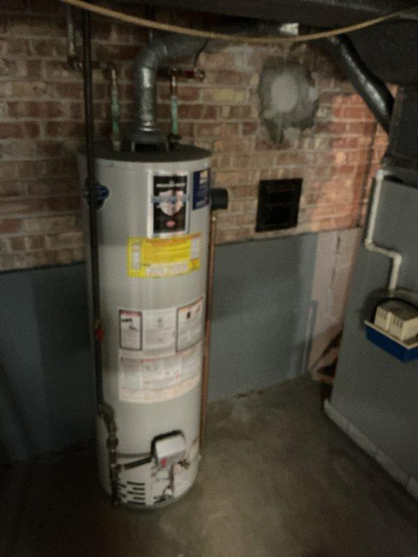 Responded to service call for water heater with extinguished pilot light resulting in no hot water. Upon arrival, inspected tanked water heater unit located in basement utility area against brick wall foundation. Assessed pilot assembly and gas supply system to determine cause of pilot outage. Successfully relit pilot light and verified proper ignition and flame characteristics. Tested thermocouple functionality and gas valve operation to ensure safe and reliable performance. Observed significant green patina corrosion on copper supply lines extending from top of unit, indicating age-related oxidation but not requiring immediate replacement. Confirmed water heater returned to normal operation with adequate hot water production. Unit restored to full service.