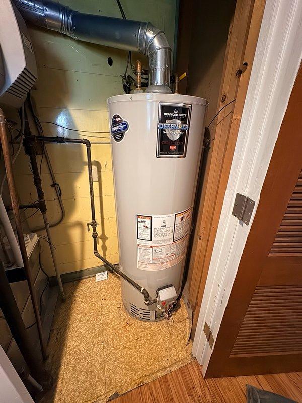 Responded to service call for reported water heater leak. Upon inspection, assessed existing tanked water heater unit installed in utility closet with standard venting and copper piping connections. Examined Honeywell gas control valve assembly, temperature controls, and pilot system for proper operation. Evaluated all plumbing connections, supply lines, and discharge piping for signs of moisture or active leaking. Inspected venting system including flexible ductwork and exhaust configuration. Verified proper installation of pressure relief valve and associated discharge tube. Documented equipment condition with detailed photographs showing water heater positioning, control components, and connection points. Discussed comfort plan renewal options and preventative maintenance services including air conditioning system evaluation.
