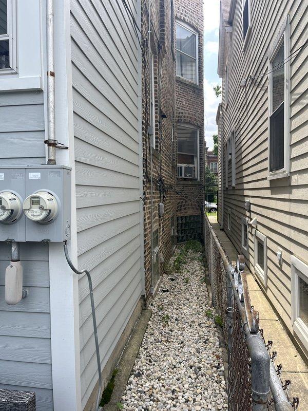 Conducted site assessment for mini-split installation at two-flat residential property currently utilizing window AC units. Evaluated existing electrical panel and determined additional breaker capacity will be required to support new mini-split system. Assessed exterior alleyway access between buildings for outdoor condenser unit placement and reviewed conduit routing options for refrigerant lines and electrical connections.
