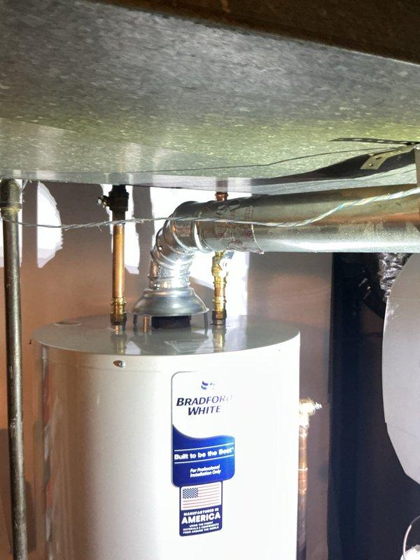 Successfully removed and disposed of the existing water heater from the basement, then installed a new Bradford White 40-gallon natural gas water heater (model BG240T6N) in the same location. Connected the unit to existing gas line, electrical supply, water supply piping, and exhaust chimney venting system using copper piping and brass fittings. Performed complete start-up procedures, tested all connections for proper operation and safety, and verified system functionality upon completion.