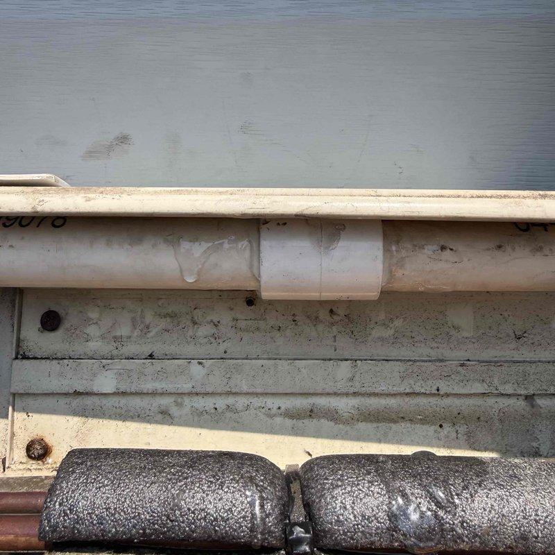 Responded to service call regarding reported system leak. Upon arrival, conducted thorough inspection of exterior condensate drainage system and refrigerant line set at foundation level. Located active leak at condensate drain line connection point where PVC T-fitting showed signs of moisture accumulation and improper drainage. Inspected insulated refrigerant lines for potential refrigerant leaks but found no evidence of refrigerant loss. Documented equipment information and photographed affected areas showing condensate drain configuration and line set installation at building foundation. Advised customer of findings and presented repair options to address condensate drainage issue and prevent future water damage.
