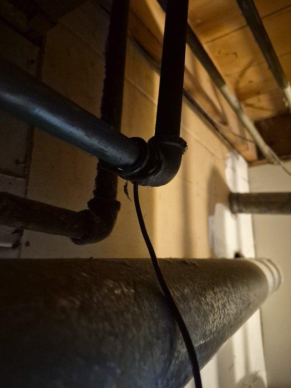 Responded to water leak complaint originating from American Standard furnace unit in basement. Upon inspection, identified moisture issue at HVAC equipment connections that customer had previously experienced approximately two months prior. Accessed components behind furnace unit to inspect copper piping connections and drain system. Examined condensate drainage system and associated PVC piping components on top of unit. Verified plumbing connections and inspected surrounding area including overhead black pipe joints and nearby water heater for potential leak sources. Documented equipment information and captured photographic evidence of work area and equipment condition for service records.