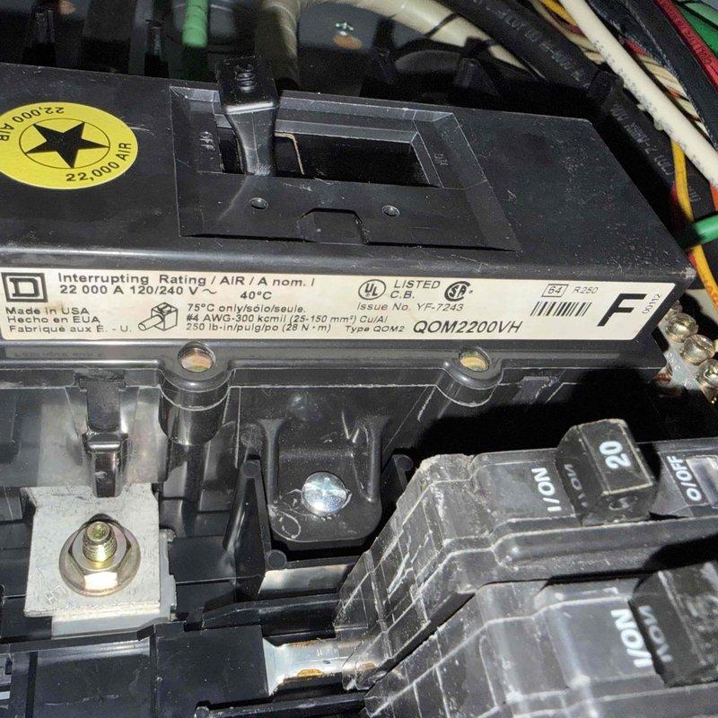 Returned to site to complete warranty work by replacing defective circuit breaker for AC unit. Removed worn 200-amp main breaker from electrical panel and installed new QOM2200VH breaker rated at 22,000A interrupting capacity, 120/240V AC. Verified proper electrical connections, tested breaker operation, and confirmed AC system functionality upon completion.