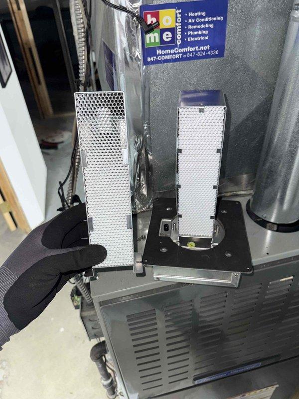 Replaced existing air scrubber unit on HVAC system. Removed old air purification device and installed new air scrubber assembly onto furnace plenum, securing all connections with proper ductwork attachments and metallic tape. Verified electrical connections to control board, confirmed LED indicator light functioning properly, and tested system operation to ensure proper air filtration performance.