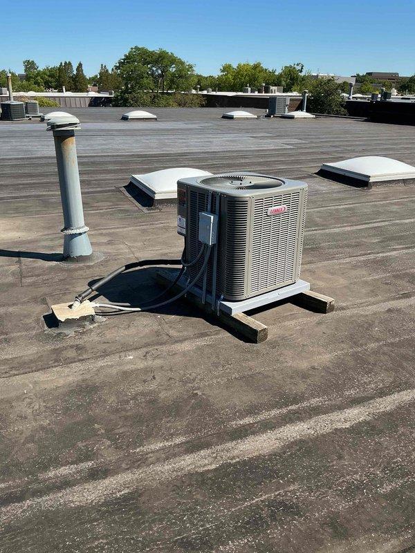 Completed installation of 2.5 ton air conditioning system with matching evaporator coil on commercial flat rooftop to work in conjunction with existing Lennox furnace. Unit was mounted on appropriate equipment pad with proper leveling, refrigerant lines were insulated and routed professionally, and all electrical connections were completed per manufacturer specifications and local code requirements.