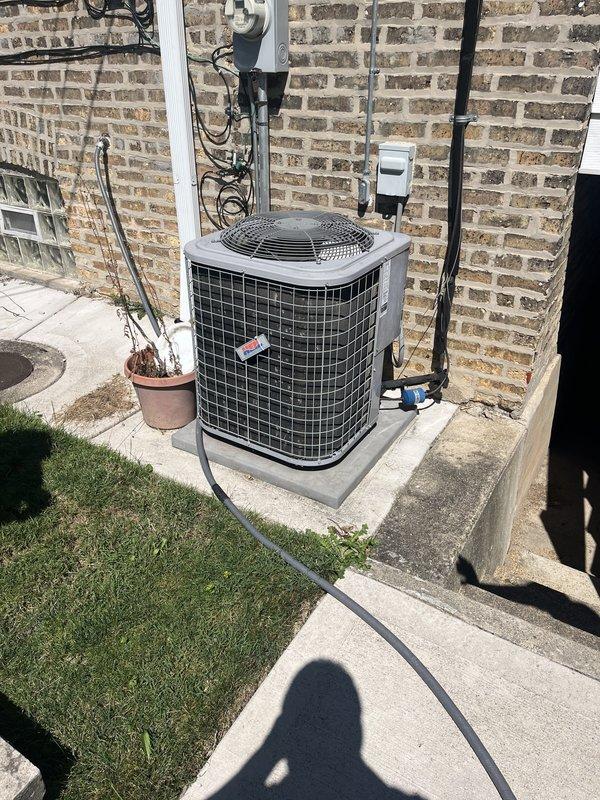Responded to service call for non-operational air conditioning system that was smoking prior to shutdown. Inspected 15-year-old outdoor condenser unit located on ground-level concrete pad in backyard. Documented existing equipment configuration including electrical disconnect, conduit routing, and Honeywell thermostat. Provided comprehensive estimate with repair and replacement options due to age of system and reported smoking condition.