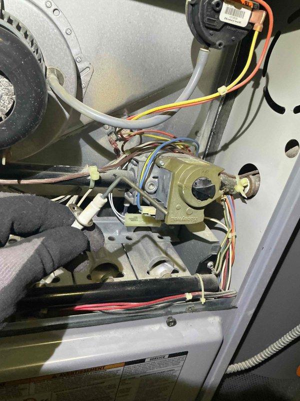 Responded to service call for multiple HVAC concerns including improper air conditioning drainage, heating unit cycling issues with temperature maintenance problems, and basement ductwork leakage. Upon arrival, performed comprehensive system inspection of air handler unit and furnace components. Examined condensate drain lines, PVC drainage system, and refrigerant lines for proper operation and potential blockages. Inspected gas valve assembly, electrical connections, and control modules for proper function. Evaluated blower motor assembly and internal mechanical components. Assessed ductwork connections in basement area for air leakage. Documented equipment specifications and current system condition through photographic evidence. Completed diagnostic evaluation of heating and cooling system to identify root causes of reported performance issues and prepared recommendations for necessary repairs.