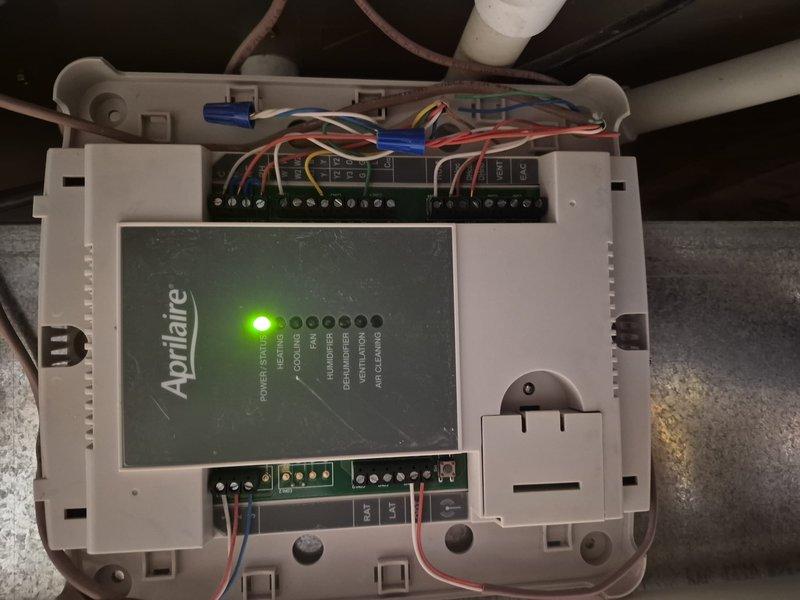 Responded to no cooling call with blank thermostat display. Upon arrival, found wall-mounted thermostat powered off and Aprilaire control board with no active display. Verified thermostat wiring connections at control board, confirmed proper wire terminations on circuit board terminals, and checked system breakers. Diagnosed loss of power to thermostat and control system, restored power to equipment, and verified proper LED indicator illumination on Aprilaire controller. System operational with thermostat display functioning and cooling cycle initiated successfully.