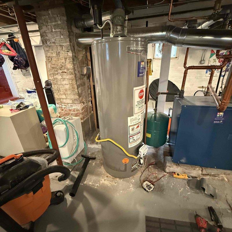 Responded to no hot water call and found pilot light extinguished on tanked water heater. Successfully relit pilot light and verified proper burner operation with characteristic blue flame. Confirmed unit returned to normal operation and hot water service restored.