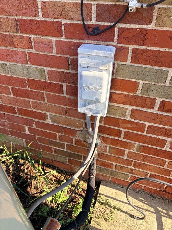 Completed pre-installation walk-through for upcoming HVAC system replacement. Documented existing outdoor condensing unit positioned on concrete pad against brick exterior wall, noting current electrical disconnect and power supply configuration. Photographed equipment placement, electrical connections, and site conditions to facilitate installation planning and ensure proper preparation for scheduled system changeout.