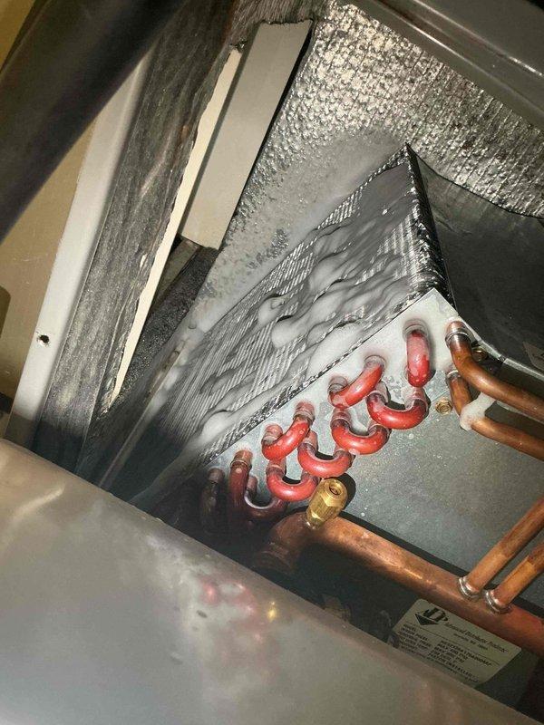 Responded to callback for persistent refrigerant leak after multiple previous service visits. Conducted thorough inspection of evaporator coil assembly and associated refrigerant lines in attic installation. Photographically documented copper line connections, brass fittings, and insulated suction lines at coil base for warranty records. System remains under investigation for source of reported leak.