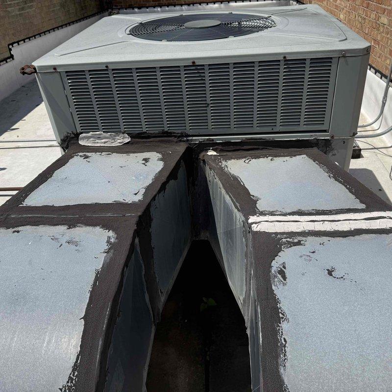 Responded to commercial rooftop unit (RTU) after 12 PM for scheduled maintenance agreement service per customer contact person. Upon arrival, accessed RTU mounted on rooftop curb and performed comprehensive system inspection. Unit found operational with condenser fan assembly functioning properly. Documented equipment condition with photographs showing beige packaged rooftop unit with horizontal louver ventilation panels. Noted rooftop membrane showing signs of weathering, algae growth, and standing water accumulation on surrounding roof surface. HVAC unit mounting platform exhibited deterioration with peeling coating and dark staining at base where platform meets roof membrane. Completed routine maintenance checks and verified proper airflow through louver vents and fan grille assembly. System operating within normal parameters at time of service completion.