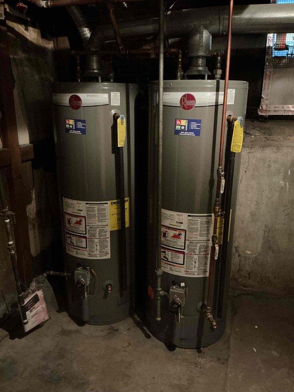 Completed Comfort Plan Clean and Check maintenance on two-system HVAC setup including furnace on main floor/basement, steam boiler, and dual Rheem water heaters. Inspected air scrubber bulb per previous estimate and evaluated humidifier operation following reports of improper installation. Documented equipment conditions with photos showing both water heater units with proper labeling, copper piping connections, shut-off valves, and overall system configuration. All equipment inspected and serviced according to maintenance plan specifications.