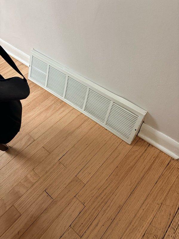 Conducted site assessment for upcoming HVAC installation or modification work. Documented existing conditions including baseboard vent grille location in main living area and entry point access through mudroom. Photographed current ventilation setup and workspace to plan equipment placement and identify any potential installation obstacles.