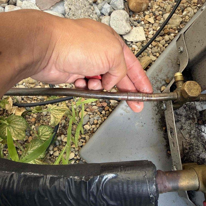 Responded to no cooling call on air conditioning system. Upon arrival, performed visual inspection of outdoor condensing unit and refrigerant line connections. System had previously experienced refrigerant leak in May during prior service visit. Inspected refrigerant lines, fittings, and service ports for signs of refrigerant loss using leak detection equipment. Documented equipment information and photographed refrigerant line connections at outdoor unit. Discussed leak search services and repair options with customer including flat rate pricing for refrigerant leak detection and system recharge with R-454B refrigerant.