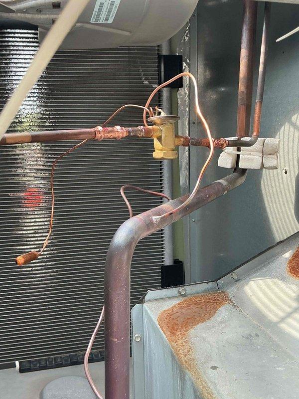 Diagnosed failed thermal expansion valve (TXV) in commercial rooftop unit causing improper refrigerant metering and inadequate cooling performance. Disassembled refrigerant circuit, recovered system charge, and removed defective TXV assembly from evaporator coil inlet. Replacement TXV has been ordered from SupplyHouse and is awaiting delivery for final installation, system recharge, and operational testing.