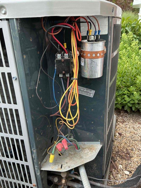 Responded to no cooling complaint on aging air conditioning system experiencing short cycling behavior. Upon arrival, performed diagnostic evaluation of outdoor condensing unit. Removed access panel to inspect electrical and mechanical components. 

Found evidence of previous refrigerant loss requiring charge earlier in cooling season, indicating potential leak in system. Inspected contactor, capacitor, and electrical connections for proper operation and signs of failure. Observed age-related wear, corrosion, and accumulated debris on electrical terminals and internal components. Documented condition of wiring connections, contactor assembly, and capacitor with photos showing visible deterioration on terminal block connections.

Evaluated short cycling condition by checking electrical components, thermostat settings, and system operation. Given the unit's age over 10 years, previous refrigerant issues, and current short cycling behavior, discussed repair options and system replacement 
