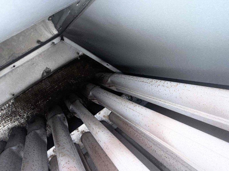 Responded to callback for hallway HVAC unit leaking near unit 403, causing visible water damage in fourth floor lobby ceiling. Upon inspection, confirmed leak source was from HVAC system rather than roof membrane. Documented excessive condensation accumulation on refrigerant lines and moisture infiltration into equipment cabinet, photographed affected components showing water droplets on insulated piping and interior cabinet surfaces with visible moisture damage patterns.
