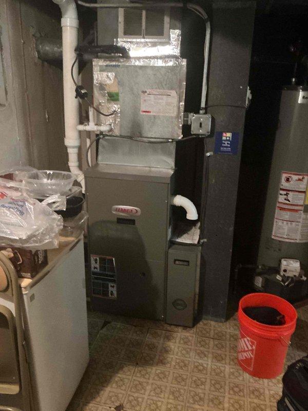 Responded to service call for air conditioning system experiencing intermittent operation issues. Performed diagnostic evaluation of Lennox HVAC system, including thorough inspection of blower motor assembly, control board, and electrical connections. Tested blower motor operation and verified proper voltage supply using multimeter. Inspected wiring harnesses for loose connections or damage, examined control board for signs of failure, and assessed overall system functionality. Documented equipment information and captured photos of furnace interior components and mechanical room setup for service records.
