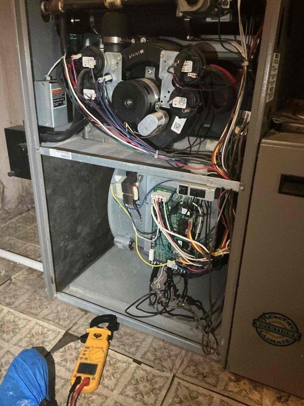 Responded to service call for air conditioning system experiencing intermittent operation issues. Performed diagnostic evaluation of Lennox HVAC system, including thorough inspection of blower motor assembly, control board, and electrical connections. Tested blower motor operation and verified proper voltage supply using multimeter. Inspected wiring harnesses for loose connections or damage, examined control board for signs of failure, and assessed overall system functionality. Documented equipment information and captured photos of furnace interior components and mechanical room setup for service records.