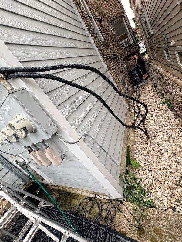 Returned to site to complete mini split installation in narrow side yard between residential structures. Outdoor condenser unit successfully mounted on vinyl siding with refrigerant lines properly insulated and secured along exterior wall using mounting brackets. All line connections completed at outdoor unit with service valves accessible for future maintenance.