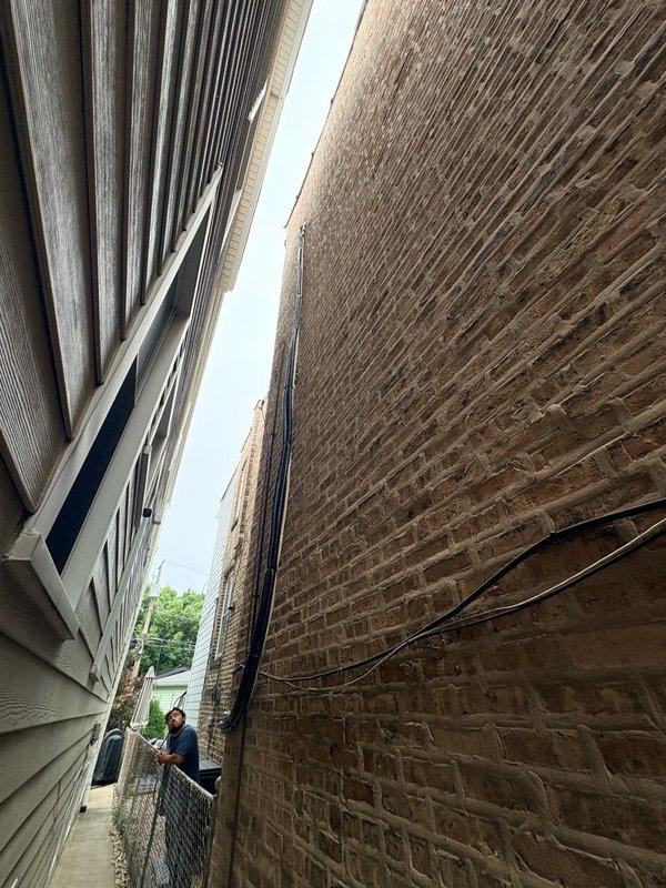 Returned to site to complete mini split installation in narrow side yard between residential structures. Outdoor condenser unit successfully mounted on vinyl siding with refrigerant lines properly insulated and secured along exterior wall using mounting brackets. All line connections completed at outdoor unit with service valves accessible for future maintenance.
