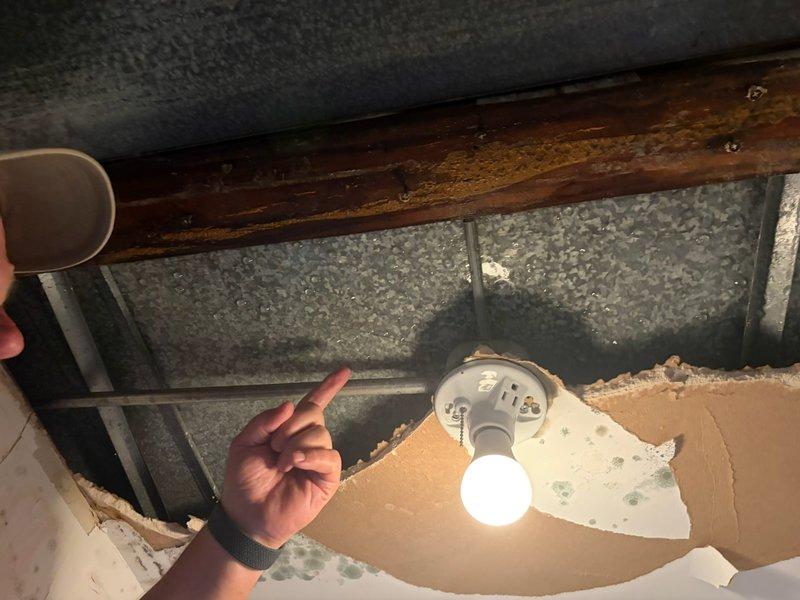 Responded to callback for recurring condensate leak from HVAC unit. Upon arrival, coordinated with drywall contractor on-site to assess water damage to ceiling materials. Inspection revealed active moisture intrusion affecting ceiling panels and wooden structural beams, with visible staining and deterioration around light fixture area. Documented extensive damage to textured ceiling materials where condensate had penetrated, exposing underlying framing and insulation. Performed thorough examination of drain line routing and condensate management system to identify source of repeat failure. Completed photographic documentation of affected areas for warranty and follow-up purposes.