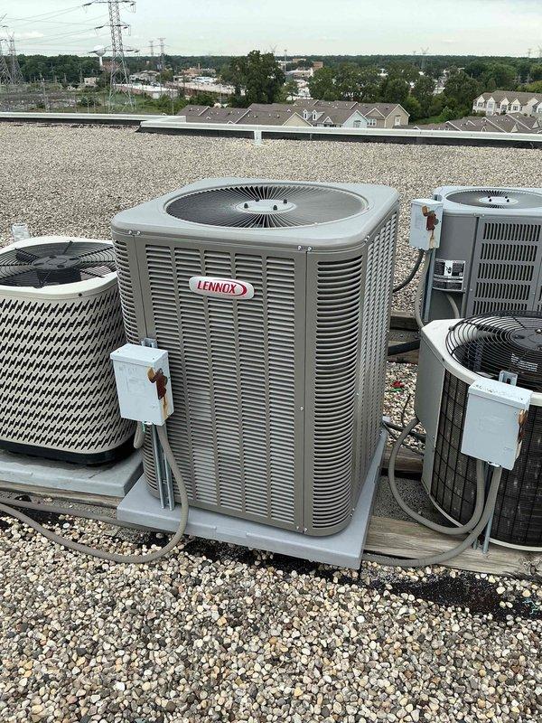Completed warranty inspection of rooftop HVAC installation. Confirmed that inline dryer was not installed as part of original equipment setup. Documented existing multi-unit configuration including Lennox condenser and additional HVAC equipment, all properly mounted on ballasted roofing system with appropriate electrical disconnects and conduit connections in place.