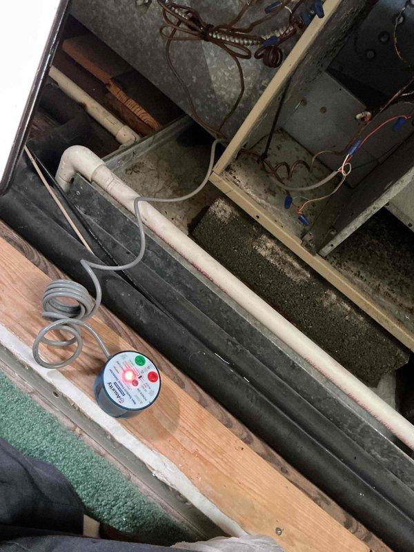 # HVAC Maintenance Call Back - Air Handler Diagnostic

Returned to service location to address ongoing air handler malfunction reported after previous service visit. Upon arrival, accessed floor cavity to inspect air handler unit, control panels, and associated electrical components. Performed comprehensive diagnostic evaluation of black cylindrical air handler unit and white electrical control boxes to identify source of continued operational issues.

Inspected refrigerant lines, monitoring gauges, and electrical connections in mechanical space. Verified proper installation of foam-insulated refrigerant lines and checked gauge readings for system pressures. Examined control wiring, ductwork connections, and PVC condensate drain routing. Documented equipment configuration and current system status with photographs for service records.

System remains under observation to determine root cause of recurring air handler performance issues. Further diagnostic work or component replacement m
