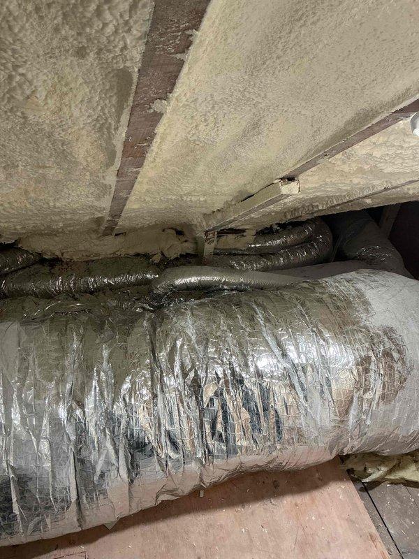 Removed kitchen range hood for access and tested electrical continuity as requested. Inspected crawl space mechanical systems including spray foam insulation application on floor joists and existing flexible ductwork. Noted deteriorated reflective wrapping on main horizontal duct run with multiple tears and peeling sections exposing underlying material. Documented condition of HVAC ductwork and insulation installation for warranty records.