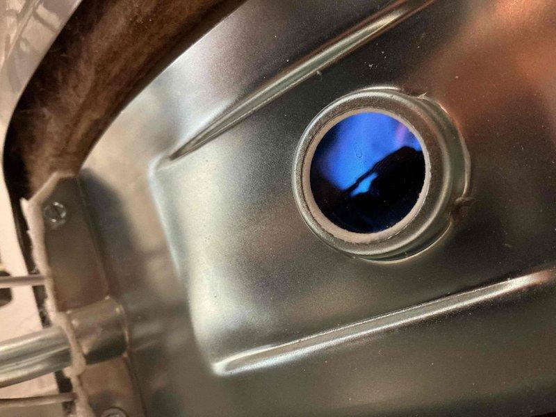 Completed vapor system replacement on residential tanked water heater. Ordered and installed replacement parts from Ferguson supply house. Verified proper gas combustion with clean blue flame at burner assembly. Inspected gas control valve, thermostat operation, and all pipe connections including copper supply lines and PVC drainage system. Confirmed unit is operating safely with all safety labels intact and control functions responding appropriately.