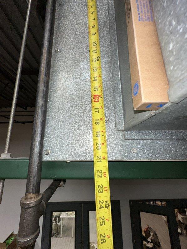 Completed comprehensive site assessment and measurements for commercial HVAC full system replacement. Documented existing ductwork dimensions and clearances in mechanical area, measuring vertical clearances ranging from 8 to 26 inches along galvanized metal ductwork and structural components. Evaluated installation space constraints including proximity to industrial shelving, exposed ceiling structure with corrugated metal decking, and existing flexible ductwork routing to ensure proper equipment fitment and code compliance for new system installation.