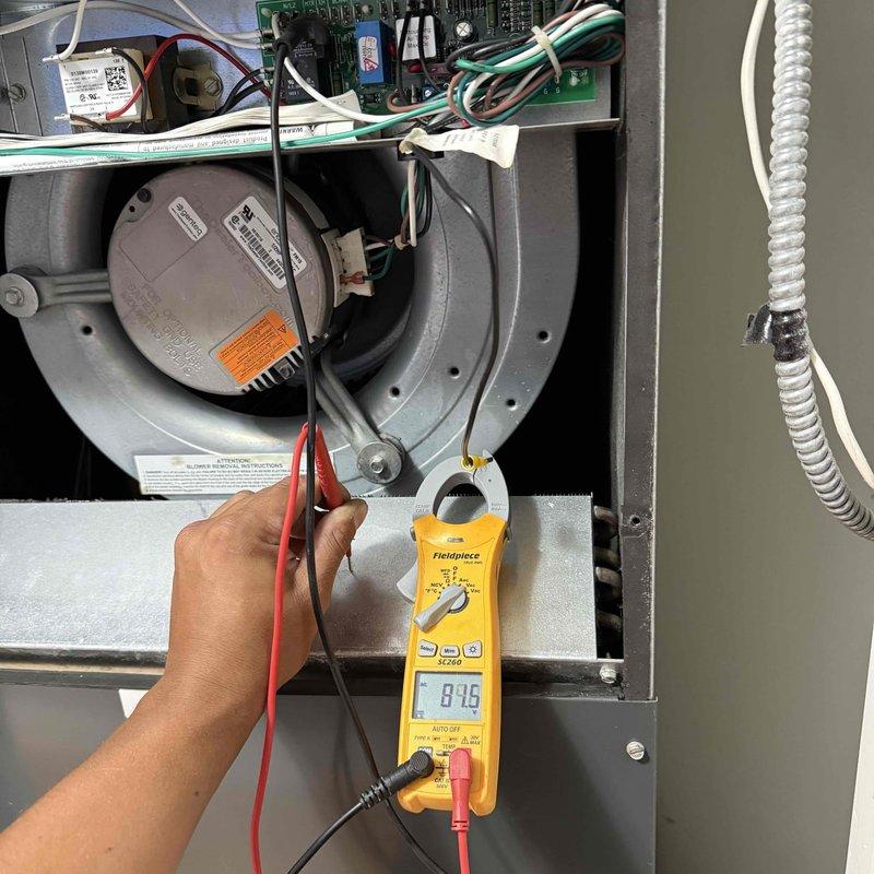 Responded to service call for AC unit making noise and cycling on and off intermittently. Upon arrival, performed diagnostic testing of the air handler system using digital multimeter to check electrical components and motor operation. Inspected blower motor assembly, control boards, and wiring connections for proper function and signs of failure. Verified drain pan and condensate line were clear and functioning properly. Took voltage readings showing 8.46V at tested component. Documented system condition with photos of internal components and overall unit installation for service records.
