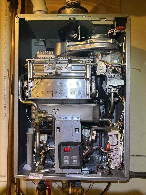 Performed comprehensive maintenance and inspection on wall-mounted tankless water heater system. Verified operation of all internal components including heat exchanger, burner assembly, and electronic control board with digital display. Confirmed proper function of brass isolation valves, water flow sensors, and exhaust venting system with PVC piping. Unit operating within manufacturer specifications with all safety controls responding appropriately.