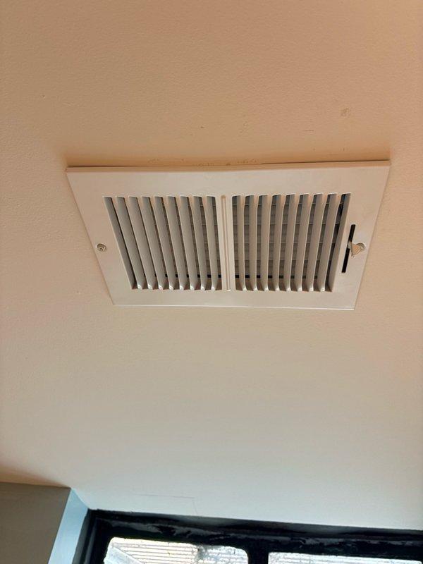 Completed installation of two white rectangular ceiling-mounted supply registers in commercial space. Both units were properly secured with mounting screws and feature adjustable horizontal slats for airflow control. Installation was coordinated during customer's available window between 2-5pm using parts previously staged at office.