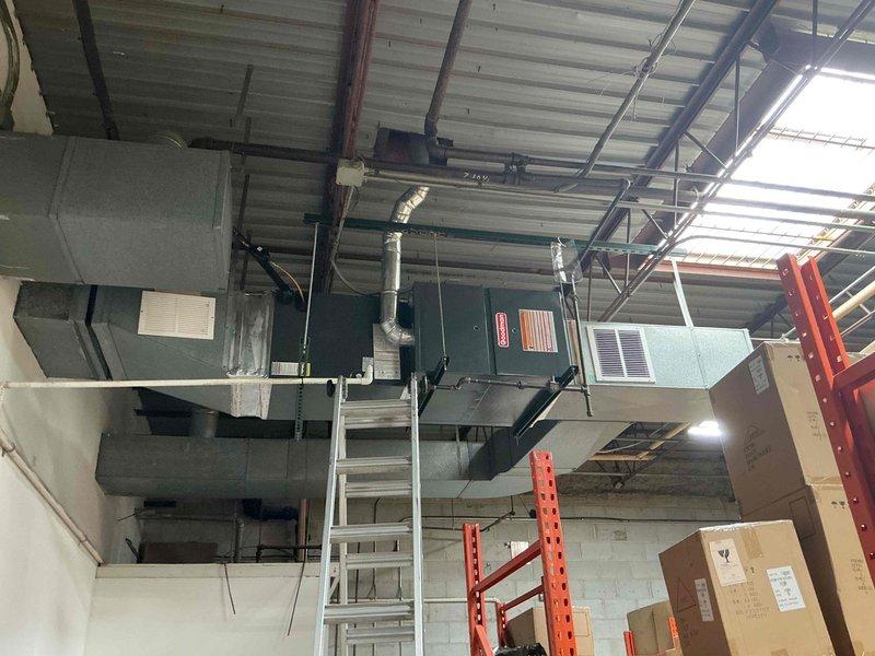 Removed existing York air conditioning unit from roof and completed installation of new 4-ton rooftop air conditioning unit with horizontal furnace mounted inside warehouse. Performed vacuum testing to verify system integrity, established proper refrigerant charge, and confirmed all ductwork connections and mechanical linkages were secure and operational.