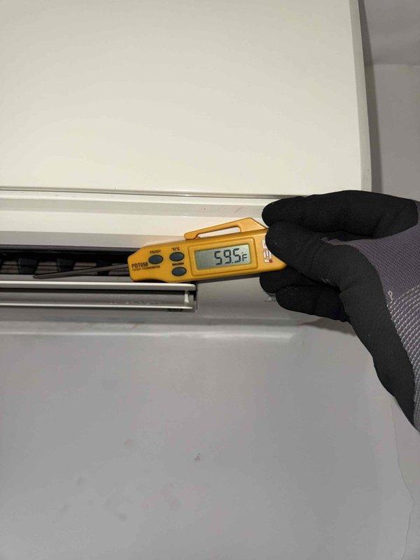 Responded to callback for wall-mounted AC unit experiencing recurring water leakage issue. Removed front panel to access internal components and inspected evaporator coil assembly and drainage system. Measured supply air temperature at 59.5°F to verify cooling operation and assess system performance during diagnostic evaluation.