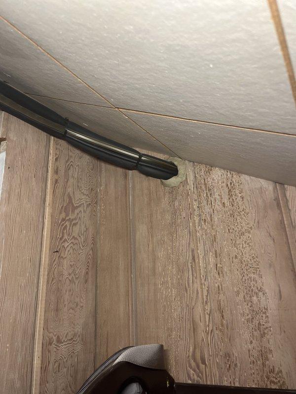 Conducted on-site evaluation for mini-split system installation in attic space. Assessed interior ceiling structure with existing copper refrigerant lines and determined optimal routing for new system components. Evaluated exterior wall penetration points and existing conduit placement along building corner to plan condensate drainage and electrical connections for outdoor condenser unit.