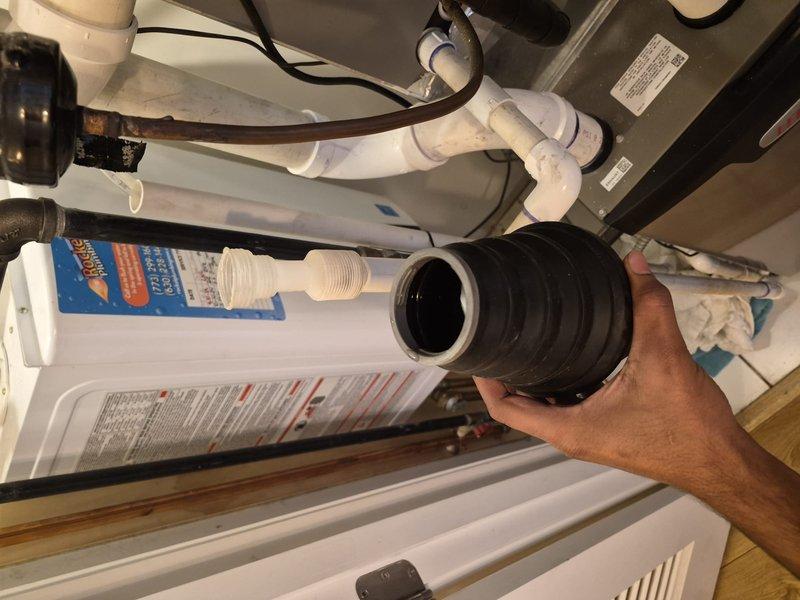 Responded to warranty call for potential condensate line clog and excess condensation from cooling system. Inspected rooftop unit with extended ladder and traced condensate drainage system through mechanical room. Located obstruction in PVC condensate drain line beneath air handler unit. Cleared blockage and installed new flexible drain coupling to restore proper drainage flow. Verified system operation and confirmed condensate removal functioning correctly with no further water accumulation.