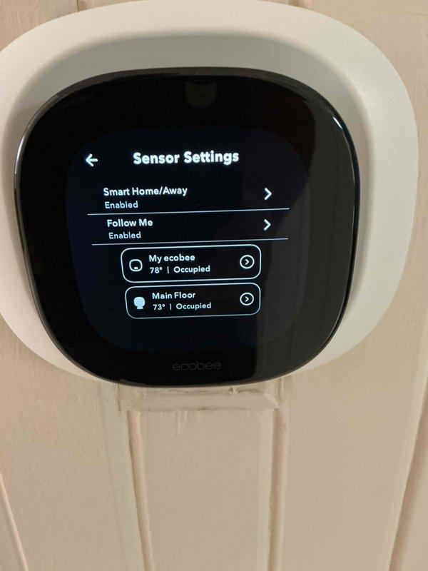 Responded to concern regarding Ecobee smart thermostat displaying incorrect temperature reading of 78°F when actual room temperature was 71°F. Upon inspection, accessed sensor settings menu and identified that thermostat was utilizing multiple remote sensors with "Smart Home/Away" and "Follow Me" features enabled. The main thermostat sensor ("My ecobee") was reading 77-78°F while the "Main Floor" remote sensor was accurately reading 73°F. Adjusted sensor participation settings to prioritize the accurate remote sensor reading and configured the averaging algorithm to provide correct temperature display. Verified system cooling operation was functioning properly and explained to occupant how the multi-sensor system operates and how sensor priority affects displayed temperature. Thermostat now displaying accurate ambient temperature based on optimized sensor configuration.