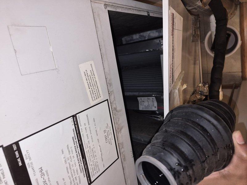 Responded to water leak originating from PVC piping connected to the air handler. Upon arrival, unit was shut off and bucket was in place collecting slow but steady water discharge. Inspected condensate drain system and identified failed or disconnected drain line connection. Removed deteriorated flexible connector and replaced with new properly-sized component. Verified all PVC connections were secure and properly sealed. Tested system operation and confirmed condensate is draining properly with no leaks present.