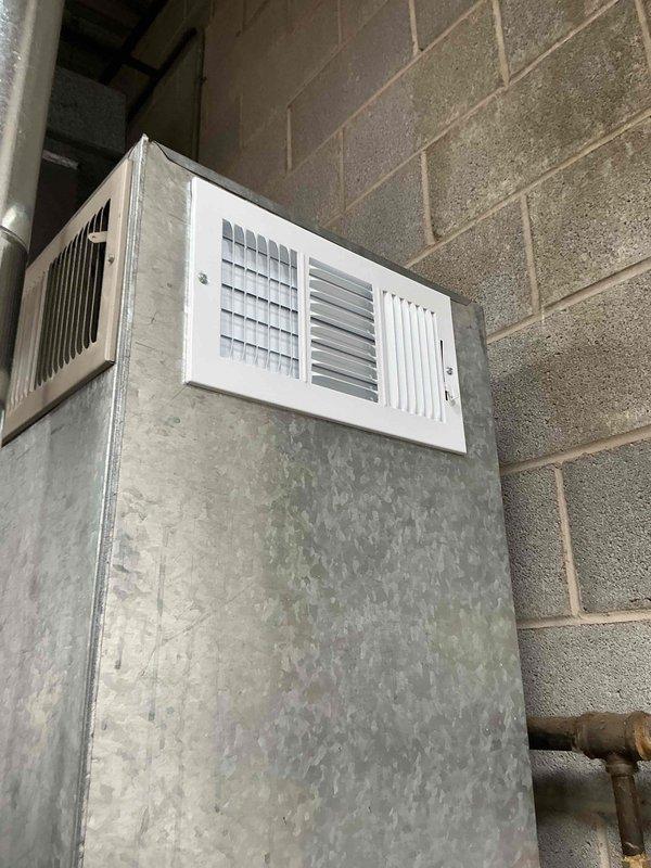Completed commercial HVAC maintenance visit to address air return system deficiencies. Installed new 14x20x1 filter and replacement white metal return air grille with horizontal slat design, ordered from supplier as specified. Performed sheet metal work to properly integrate grille with existing rectangular galvanized ductwork mounted on concrete block wall in basement mechanical room, ensuring secure attachment and proper air flow functionality.