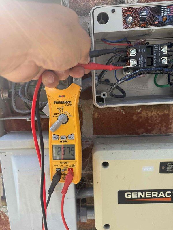 Responded to air conditioning service call for a two-year-old system. Upon arrival, performed diagnostic testing on the electrical control panel using a digital multimeter, measuring voltage readings at 13.75V on the control circuit. Inspected wiring connections, terminal blocks, and contactor relay components within the control enclosure. System appeared to be integrated with a Generac backup power system, requiring verification of proper electrical supply and transfer switch operation. Documented equipment configuration and electrical measurements for service records.