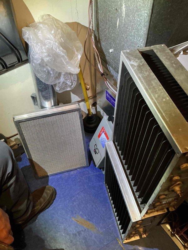 Performed comprehensive commercial HVAC maintenance agreement service on dual air handling system. Accessed facility through designated rear entrance following security protocols. Conducted complete inspection and maintenance of furnace units, humidifier, electronic air cleaner, and water heater per contract coverage plan.

Inspected two side-by-side air handling units showing dust accumulation on surfaces and filter assemblies. Examined copper refrigerant lines with insulation sleeves and verified proper routing of flexible metal conduit. Noted visible water staining on galvanized ductwork requiring monitoring. Removed and inspected blower motor assembly, identifying significant rust and corrosion on blower wheel and housing components indicating advanced age and wear. Assembly showed brown and orange discoloration throughout fan blades and metal surfaces.

Performed standard maintenance procedures including filter inspection, electrical connection verification, and component assessme