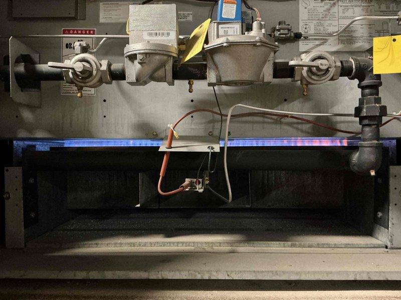 Responded to no-heat call at commercial building following power outage. Upon arrival, found hot water boiler system non-operational after power restoration. Inspected burner assembly, gas valves, and ignition controls; verified gas supply and electrical connections were intact. Reset boiler control system, checked flame sensor operation, and successfully relit burners with proper blue flame combustion visible. Confirmed system returned to normal operation with hot water circulation restored to building.