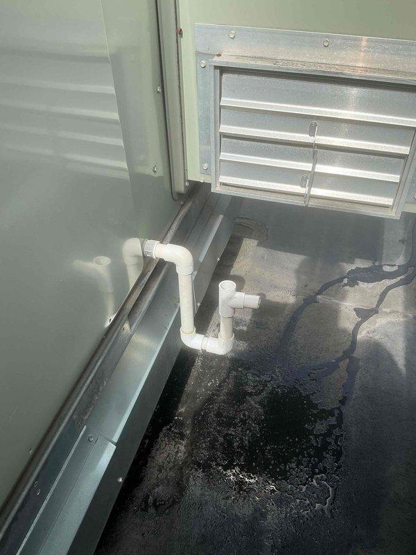 Responded to commercial HVAC service call for RTU 5 upper unit experiencing condensate drainage issues with standing water accumulation in mechanical room. Retrieved replacement P-trap materials from supplier and installed new PVC P-trap assembly to restore proper condensate drainage function. Verified system draining correctly upon completion and documented pre- and post-repair conditions.