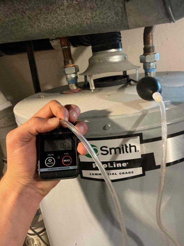 Performed water heater carbon monoxide testing per preventive maintenance protocol. Conducted safety inspection of Smith ProLine commercial-grade water heater, including verification of proper combustion and venting. Carbon monoxide levels measured at 15 PPM at time of testing. Inspected interior HVAC components through access panel, noting accumulated dust and debris in collection pan typical of normal operation. Documented equipment condition with photographs for service records.